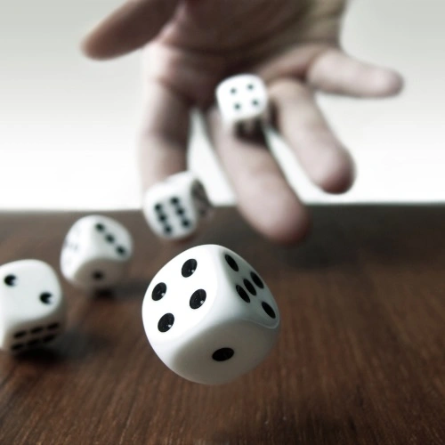 Hand throwing dice, symbolising the risk and uncertainty in sales hiring decisions.